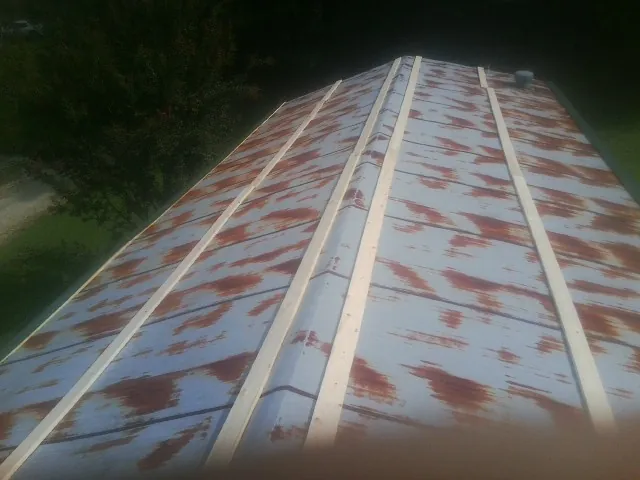 Rusted metal roof panels with new wood purlins before replacement — Storm Damage Roof Repair in Alburnett by Roofing Brothers